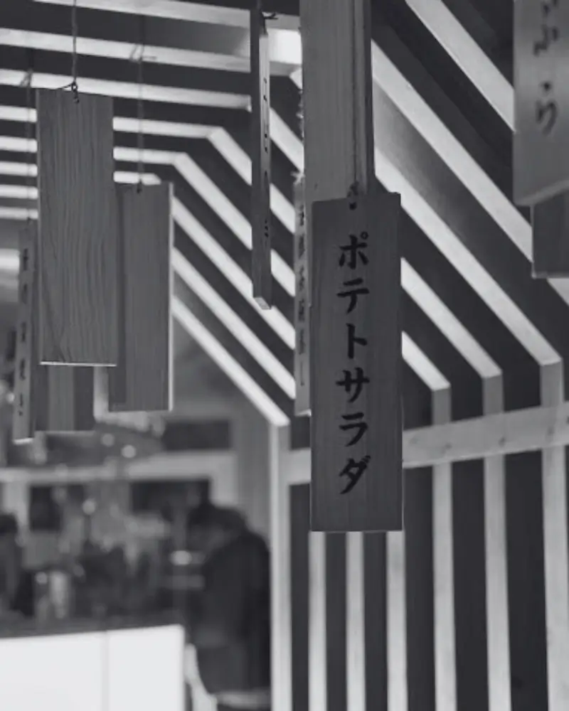 Panneaux suspendus en bois avec inscriptions japonaises dans le restaurant Umiyama Bordeaux, ambiance traditionnelle